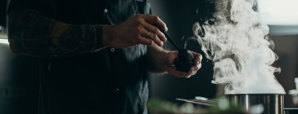 Chef preparando comida con una olla humeante